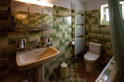 uma casa de banho com um lavatório e um WC em GLAFKOS HOUSE em Kalathas