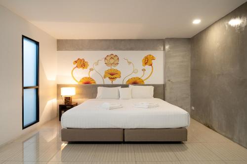a bedroom with a bed with a flower painting on the wall at The Riche Boutique Hotel Don Mueang Airport in Bangkok