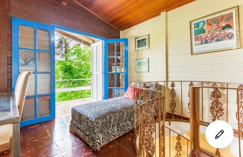 Zimmer mit einem Bett und einer offenen Tür in der Unterkunft Chacara Mairipora Essence in Mairiporã