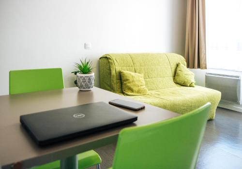 a table with a laptop on it with a couch at Twenty Business Flats Marseille Timone in Marseille