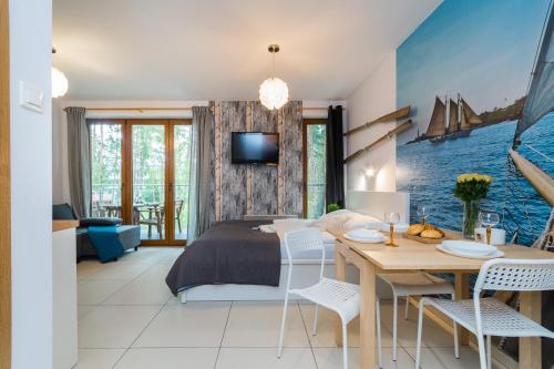 sypialnia z łóżkiem, stołem i krzesłami w obiekcie Apartamenty NCNK Baltic Park w Stegnie - 500 m do plaży w Stegnie
