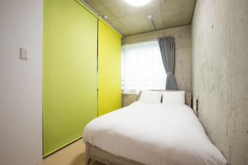 um quarto com uma cama branca e uma parede verde em Laffitte Okachimachi - Vacation STAY 8303 em Tóquio