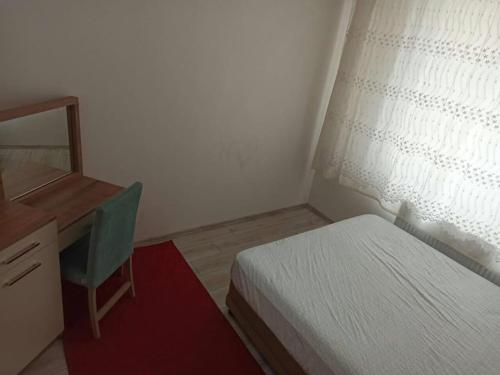 1 dormitorio con cama, escritorio y ventana en Home Home en Çavuş