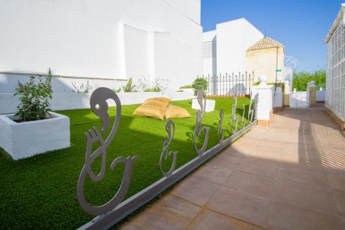 a garden with a sign on the grass at Apartamentos Sharis in Jerez de la Frontera