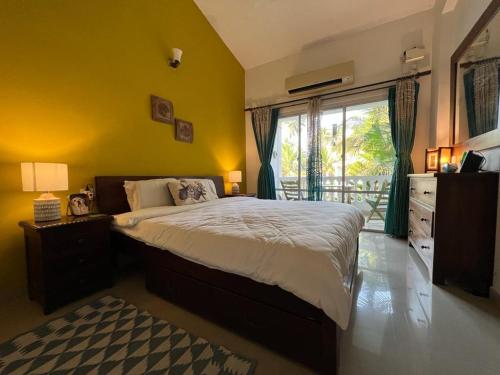 a bedroom with a large bed and a window at Riverside Villa at Siolim in Siolim