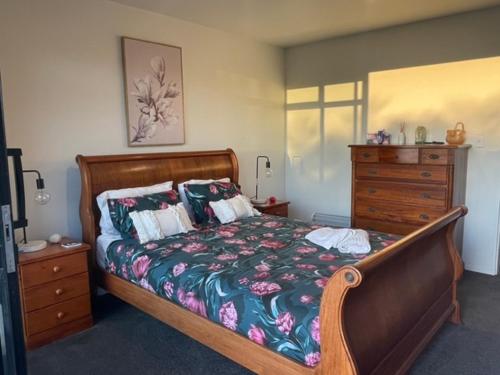 een slaapkamer met een houten bed en een dressoir bij Moana BnB, Waikawa Bay, Picton in Waikawa