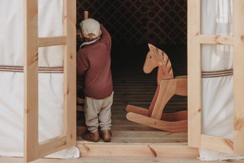 a man is standing in a doorway with a horse at Hotel Schwarzschmied in Lana