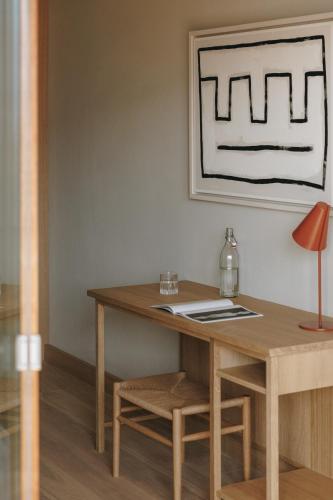 a wooden desk in a room with a table and a lamp at Hotel Schwarzschmied in Lana