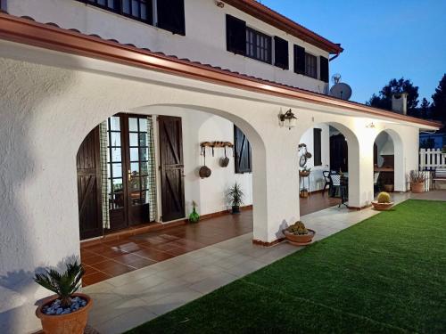 - une vue sur l'extérieur d'une maison avec une pelouse verdoyante dans l'établissement Elvira Casa Vacanze, à Iglesias