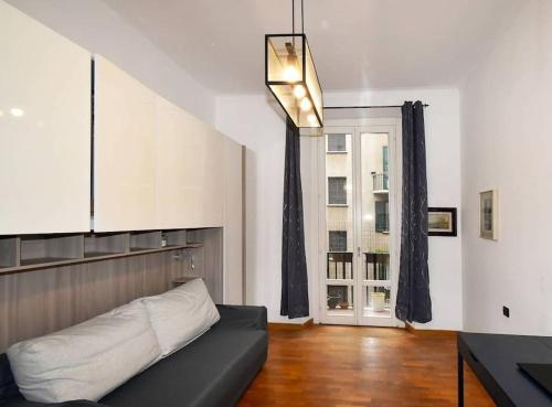 uma sala de estar com um sofá e uma janela em Trilocale Centrale - Buenos Vibes em Milão