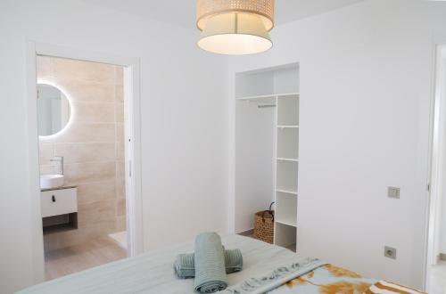 ein weißes Schlafzimmer mit einem Bett und einem Badezimmer in der Unterkunft VILLA BELLA in L'Ampolla