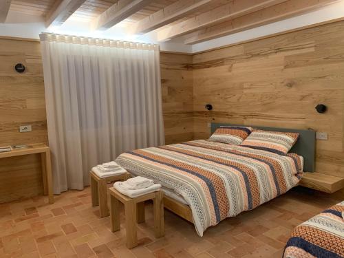 a bedroom with a large bed with wooden walls at Borgo Cortivi b&b in Valdobbiadene