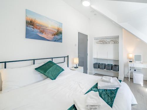 una camera bianca con un grande letto e un dipinto sul muro di Three - Uk43701 a St Anne's-on-the-Sea