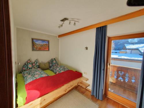 1 dormitorio con 1 cama en una habitación con ventana en Ferienwohnungen Riedl en Scharnitz