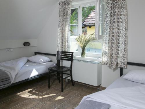 a bedroom with a chair in front of a window at Varad INN in Novi Sad