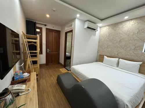 a bedroom with a bed and a phone and a television at The Land Hotel & Apartment in Vung Tau