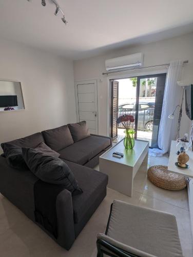 ein Wohnzimmer mit einem Sofa und einem Tisch in der Unterkunft DreamIsland Maisonette Protaras in Paralimni