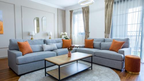 - un salon avec un canapé bleu et une table dans l'établissement GOODWOOD SUITES HOMES VACATION, à Dubaï