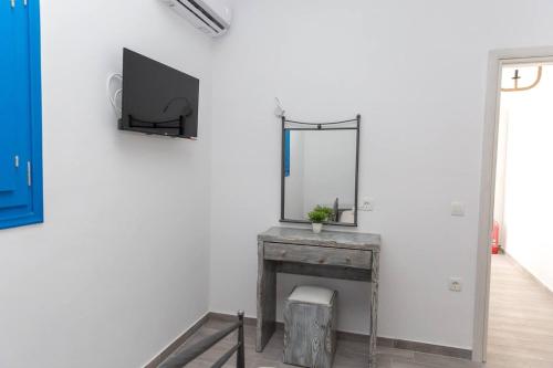 a white room with a mirror and a table with at Santorita Suites in Akrotiri