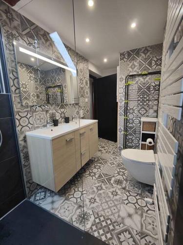 La salle de bains est pourvue d'un lavabo, d'une baignoire et de toilettes. dans l'établissement Appartement Le Baroque en duplex, à Mulhouse