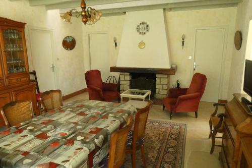 un salon avec une table et une cheminée dans l'établissement Maison entière 3 chambres, à Saint-Brévin-les-Pins