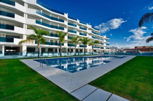 ein großes Apartmenthaus mit einem Pool und Palmen in der Unterkunft Perfect apartment 3 - TCM in Fuengirola