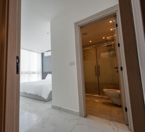 a bathroom with a shower and a toilet in a bedroom at Al Kawther Hotel Apartments in Amman