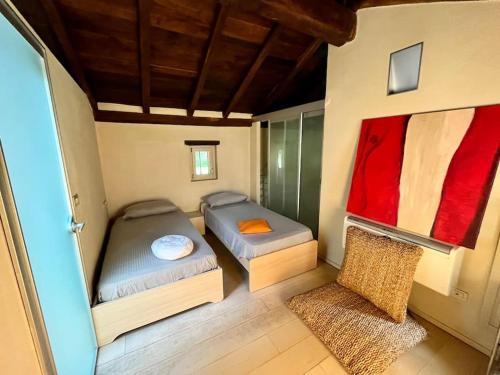 Cette chambre comprend 2 lits et une chaise. dans l'établissement Borgo Storico Il Casetto, à Sasso Marconi