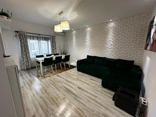 sala de estar con sofá verde y mesa en MG Mamaia North Villa en Mamaia-Sat