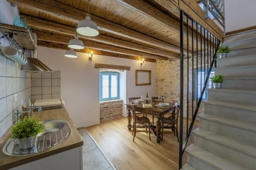 une cuisine et une salle à manger avec une table et un escalier dans l'établissement Wine & Heritage - Johan i Matija in Grandići - Istrien, à Grandići