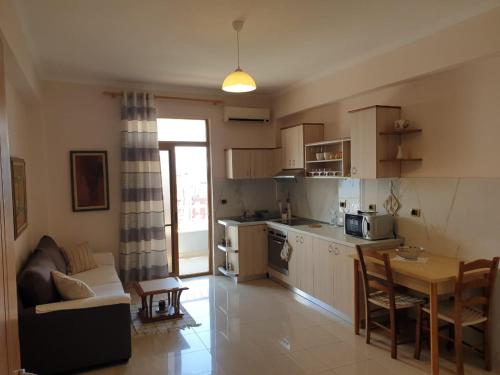 een keuken en een woonkamer met een tafel en een bank bij Jozi Kaiser Apartment 3 in Durrës