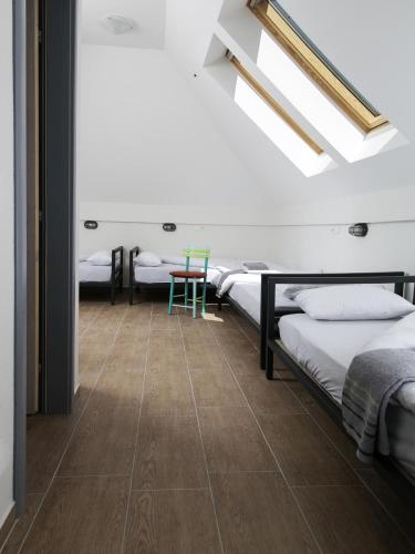 a room with four beds and a table in it at Varad INN in Novi Sad