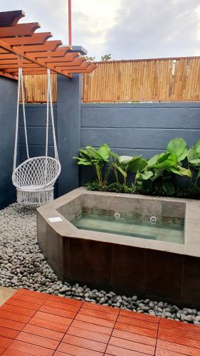 a hot tub in a garden with a swing at The Farm Shack by SMS Hospitality in Amadeo