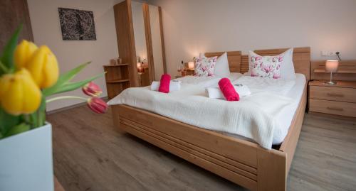 a bedroom with a large bed with pink pillows at Weingut Erich Serwazi in Mesenich