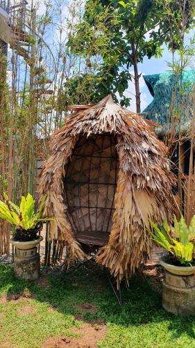 a small house made out of grass with two plants at The Farm Shack by SMS Hospitality in Amadeo