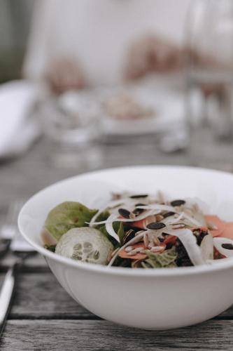 a white bowl of food on a wooden table at Hotel Schwarzschmied in Lana