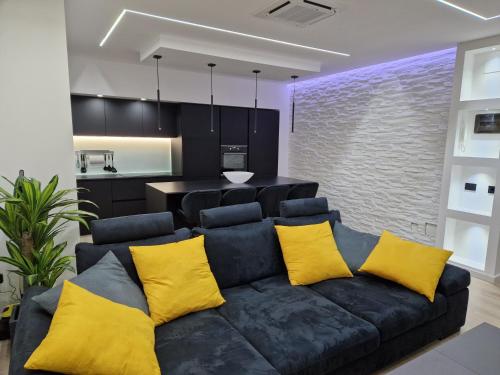 uma sala de estar com um sofá preto com almofadas amarelas em LA CASA DI TIAGO em Palermo