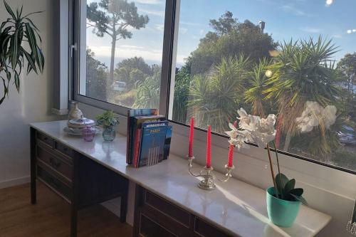 a desk with a window with red candles and books at Viewpoint - Lovely Nature View in Machico