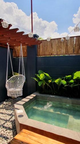 a backyard with a swimming pool and a swing at The Farm Shack by SMS Hospitality in Amadeo