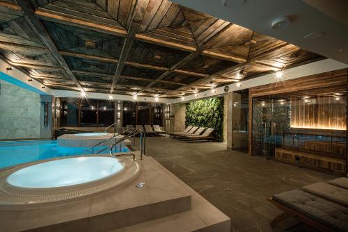 a large bathroom with a tub and a pool at Hotel Zamek Ryn in Ryn