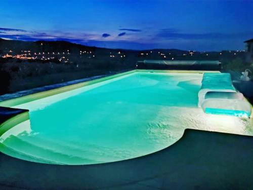 una piscina vacía por la noche con luces azules en Au cœur des vignes Moulin à Vent en La Chapelle-de-Guinchay