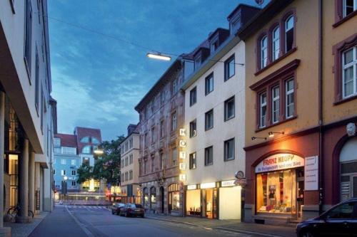 a city street with buildings and a car parked on the street at Central Hotel Garni in Würzburg