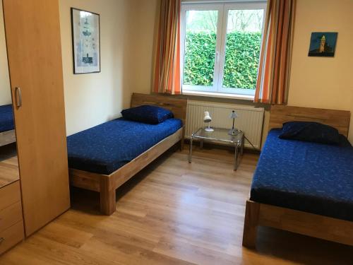 1 dormitorio con 2 camas y ventana en Hello Zeeland - Vakantiehuis Het Heem 39, en Breskens