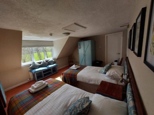 a hotel room with two beds and a couch at The Cnoc Hotel in Beauly