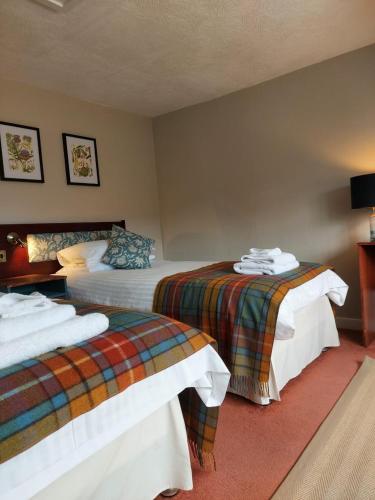 a hotel room with two beds in a room at The Cnoc Hotel in Beauly