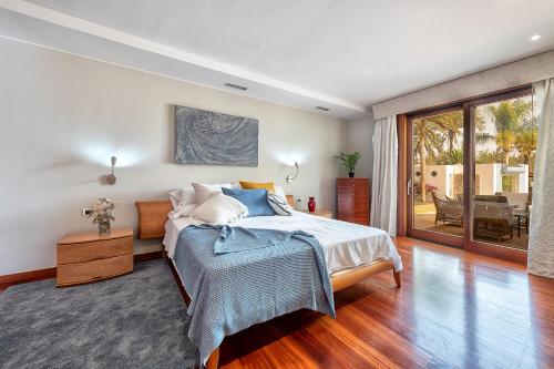 a bedroom with a bed and a sliding glass door at Luxury Villa Maspalomas Golf in Maspalomas