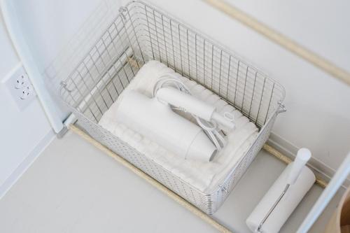 een witte mand met handdoeken in een kamer bij 自由自屋 in Nachikatsuura