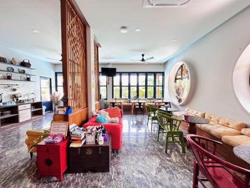 a living room with a red couch and chairs at The Luna in Nai Yang Beach