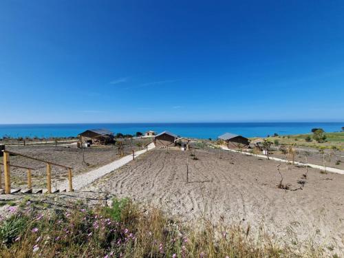 a beach with houses and the ocean in the background at Tendu' Punta Bianca Glamping Camp in Palma di Montechiaro