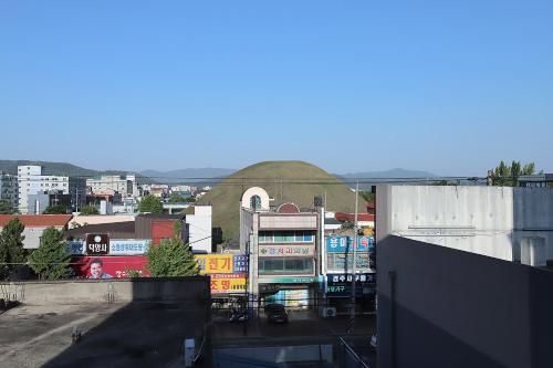 a view of a city with a hill in the background at Stay RomanticTrip_Hostel in Gyeongju